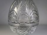 une image représentant un œuf en verre transparent posé sur un socle