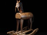 a wooden rocking horse with a horse head on it