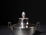 an image of a silver pot sitting on top of a black table