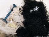 un ours en peluche noir et blanc assis au sommet d'un tas de plumes