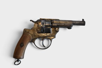 an old revolver with a wooden handle on a white surface