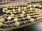 many different types of pearls and chains on a table