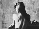 black and white photograph of a naked woman sitting on a chair