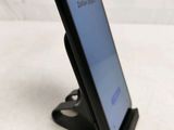 a close up of a cell phone on a stand on a white surface