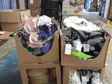 Des cartons de vêtements sont empilés les uns sur les autres dans un entrepôt