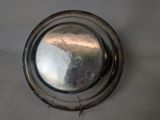 a silver plate on the wall with a mirror on it