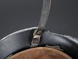 an old helmet with a leather band and a leather strap