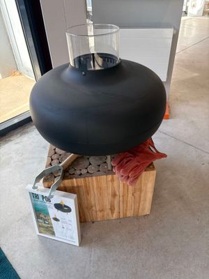 un vase noir posé sur un bloc de bois