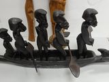 carvings of people in a boat with paddles on a table