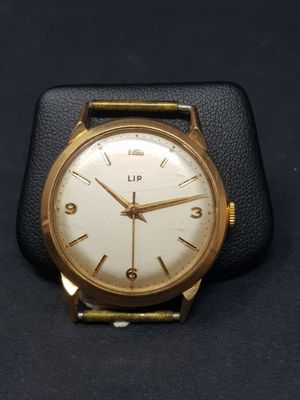 une image d'un gros plan d'une montre-bracelet sur une surface noire