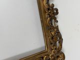 a picture of a gold frame hanging on a wall