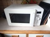 a white microwave sitting on top of a kitchen counter