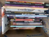plusieurs livres empilés dans une boîte