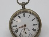 a small pocket watch with roman numerals on it