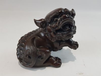 statue représentant un chien assis sur ses pattes arrière, la gueule ouverte
