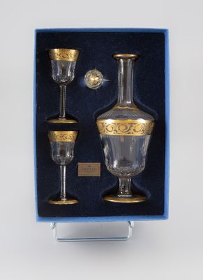 un verre présenté dans une boîte bleue ornée d'un motif doré