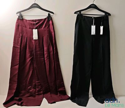 pair of women ' s pants hanging on a hanger in front of a white wall