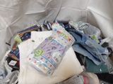 a pile of baby clothes and other items in a bin