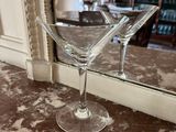 two martini glasses sitting on a table in front of a mirror