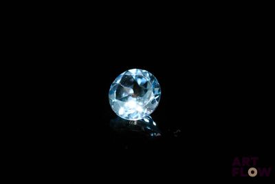 a close up of a blue topaz diamond on a black surface