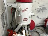 a red bucket sitting on top of a white machine