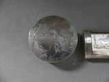 a silver coin and a silver watch on a table