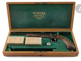 un vieux pistolet dans un coffret en bois, avec une boîte de cartes