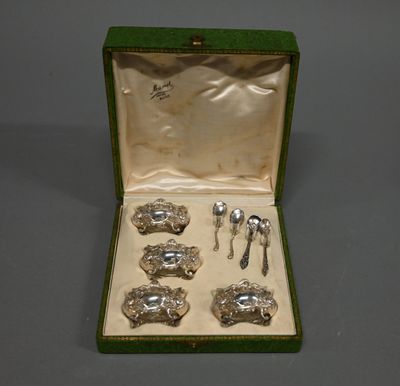 des couverts dans une boîte verte posée sur une table avec un fond gris