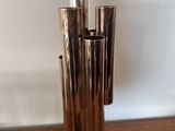 a metal vase that is sitting on a wooden table