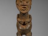 une statue en bois représentant un homme au sourire radieux