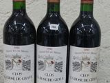 trois bouteilles de vin posées sur une table l'une à côté de l'autre