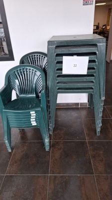 two green plastic chairs and a table in a room