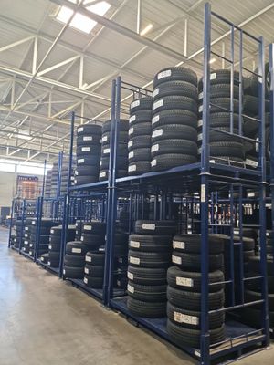a lot of tires stacked on a rack in a warehouse
