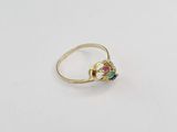un gros plan d'une bague en or sertie d'une pierre verte, rouge et bleue