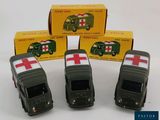 four toy cars are lined up in a row in front of a box