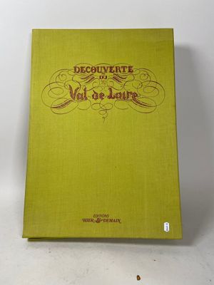 un livre vert posé sur une table à côté d'un mur blanc