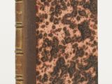an old book sitting on top of a white table next to a white wall