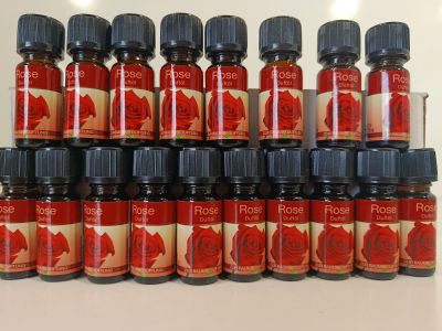 plusieurs flacons d'huile essentielle de rose posés sur une table