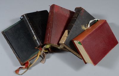 cinq vieux livres empilés les uns sur les autres sur une table