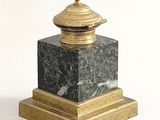 a black and gold marble pedestal with a gold lid