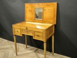 a small wooden desk with a mirror on top of it