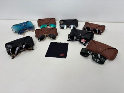 several pairs of sunglasses are laid out on a white surface