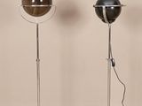 three floor lamps on a wooden floor in front of a beige wall