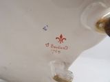 a close up of a white vase with a brown handle