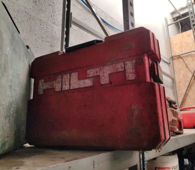 une caisse à outils rouge posée sur une étagère dans un garage