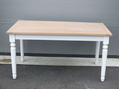 une table blanche avec un plateau en bois dans la rue