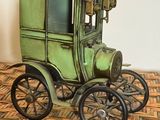 une petite voiture verte posée sur une table en bois