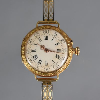 a gold wrist watch with roman numerals on the face
