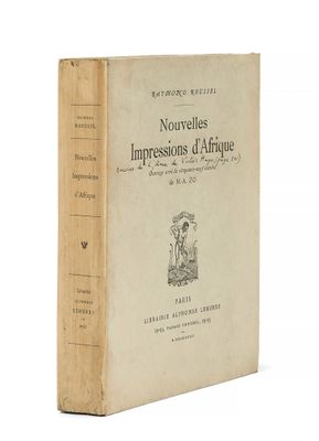 un vieux livre posé sur une table à côté d'un mur blanc