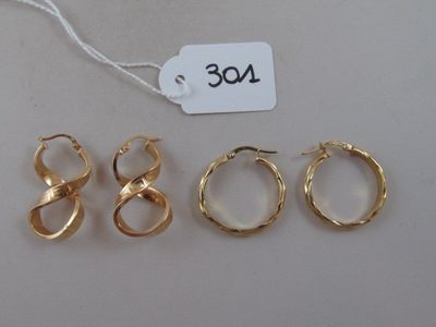 three pairs of gold hoop earrings with a price tag